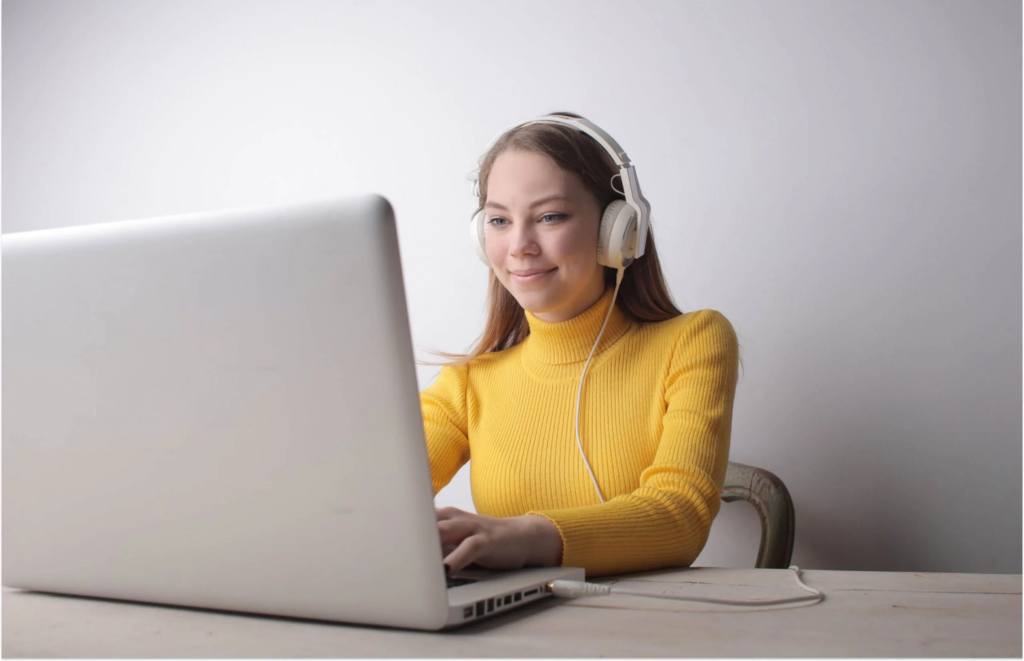 A friendly customer support agent wearing a headset, working on a laptop - entry level remote jobs