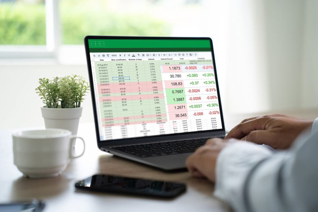 A close-up of hands typing on a laptop with spreadsheets open on the screen - entry level remote jobs