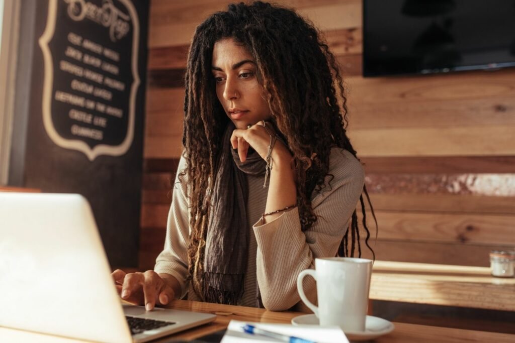 A freelancer working from a laptop at a coffee shop, with a to-do list visible on the desk - best online business ideas