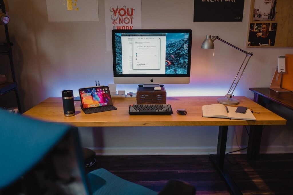 A clean home workspace setup with a laptop, headset, and desk - remote customer service jobs with no experience