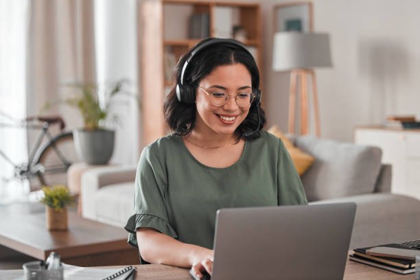 A simple photo of a person working remotely at home, wearing a headset and smiling while on a video call - remote customer service jobs with no experience