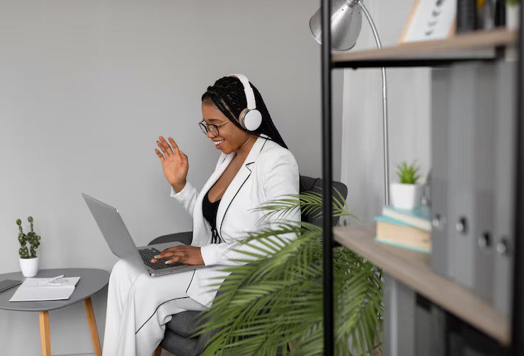 A cheerful remote worker chatting online wearing a headset - customer service jobs from home