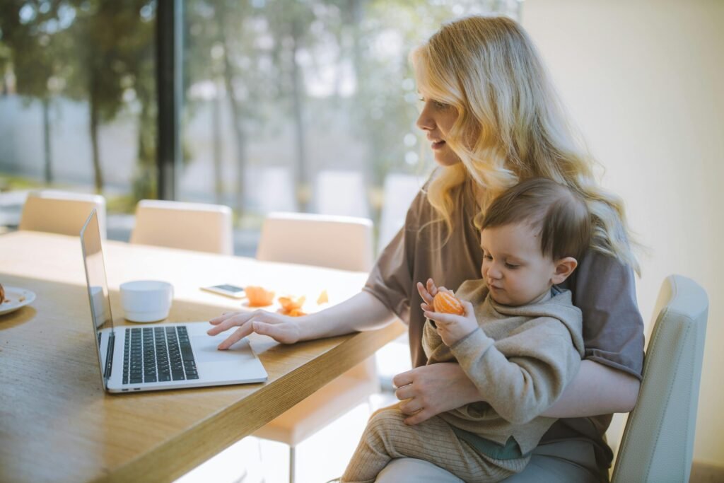 A stay-at-home mom with her son working on her laptop on her online business